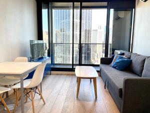 a living room with a couch and a table at Readyset Apartments at Empire in Melbourne