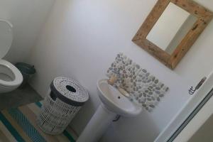 La salle de bains est pourvue de toilettes, d'un lavabo et d'un miroir. dans l'établissement Huis Maria in Golden Mile, à Stompneusbaai