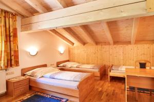 two beds in a room with wooden walls at Bichlgut in Bischofshofen