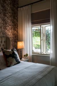 a bedroom with a bed and a window at Cape Vue Country House in Franschhoek
