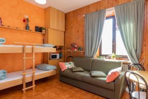 salon z kanapą i łóżkiem piętrowym w obiekcie Comfort studio centro Aprica vicino piste da sci w mieście Aprica +16 zdjęć