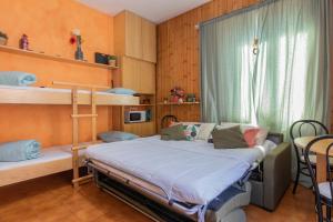 a bedroom with a bunk bed and a table at Comfort studio centro Aprica vicino piste da sci in Aprica