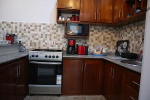 a small kitchen with a stove and a microwave at Jambo Jambiani Beach Villa, Beautiful private villa at 2 minutes from the Beach in Jambiani