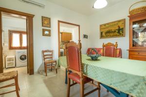 una sala da pranzo con tavolo e sedie verdi di Residence San Martino a Marina di Mancaversa