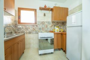 una cucina con piano cottura bianco e lavandino di Residence San Martino a Marina di Mancaversa