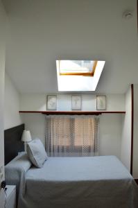 a bedroom with a bed and a window with a skylight at Hotel Alameda in Zarautz