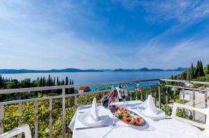 a table with a plate of food and a view of the water at Apartments Cypress Sea Cove in Slano