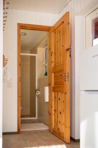 a bathroom with a shower and a wooden door at Tehumardi Camping in Salme