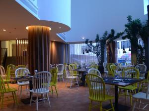 - un restaurant avec des tables et des chaises dans une salle dans l'établissement Yunna Hotel Lampung, à Bandar Lampung