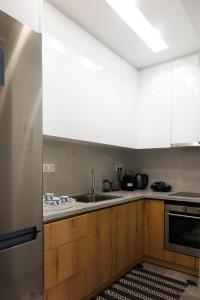 a kitchen with white cabinets and a stainless steel refrigerator at Opus Suite in Ierápetra