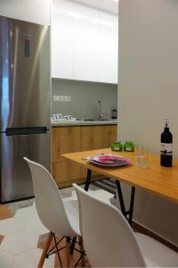 a kitchen with a wooden table and a stainless steel refrigerator at Opus Suite in Ierapetra