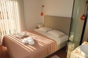 um quarto com uma cama com toalhas brancas em Opus Suite em Ierápetra