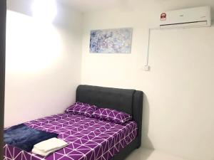 a bedroom with a purple bed with purple pillows at Chempaka Homestay (Near to UTP UiTM Seri Iskandar) in Seri Iskandar