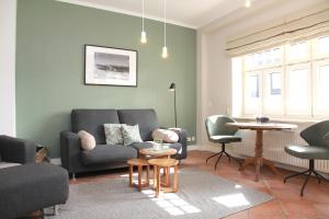 sala de estar con sofá, sillas y mesa en Villa Gudrun, en Westerland