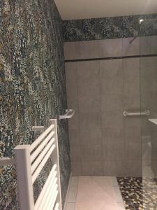 La salle de bains est pourvue d'une douche avec une porte en verre. dans l'établissement Les Charmilles, à Quettehou