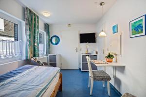 a room with a bed and a desk and a table at Nordhaus Ferienwohnung 6 in Duhnen
