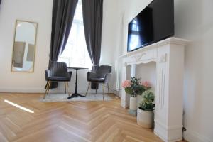 a living room with a tv and a table and chairs at Zu Besuch im Palast - Perfekte Lage in Dresden