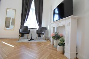 sala de estar con TV, mesa y sillas en Zu Besuch im Palast - Perfekte Lage, en Dresden