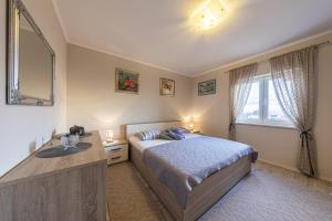 1 dormitorio con cama, lavabo y ventana en Apartments Kristić, en Dubrovnik