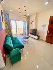 a living room with a green couch and a television at Cookies Homestay Vung Tau Gold Sea (Căn Hộ Biển) in Vung Tau