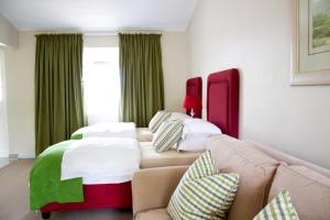 a living room with two beds and a couch at Nuwerus Lodge Paarl in Paarl