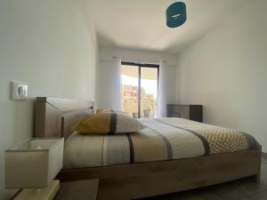 um quarto com uma cama e uma janela em Appartement T2 de standing avec parking à 250 mètres de la plage, route des Sanguinaires, Ajaccio em Ajaccio