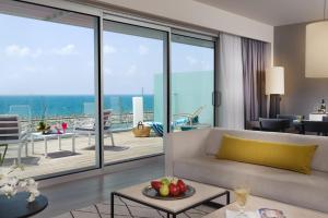 a living room with a couch and a view of the ocean at Herods Herzliya in Herzliya