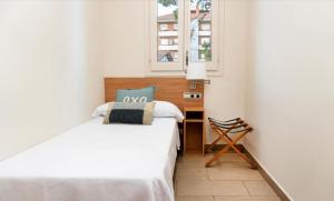 a small bedroom with a bed and a window at Kalima Beach in Caldes d'Estrac