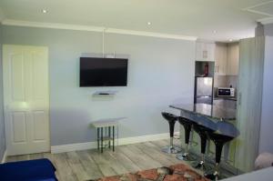 une cuisine avec une table et une télévision murale dans l'établissement Birds Holiday Accommodation 2, au Cap