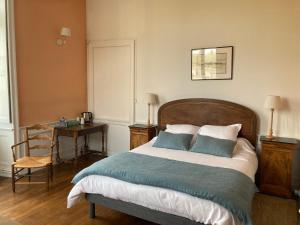 a bedroom with a bed with blue and white pillows at Le Plessis in Orvault