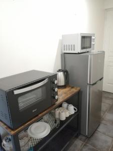 a kitchen with a microwave and a refrigerator at Séjour à la campagne in Bouhy