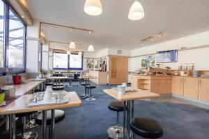 a restaurant with tables and stools in a room at T3 Budget Berlin Hennigsdorf in Hennigsdorf