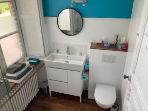 uma casa de banho com um lavatório branco e um espelho. em Le Plessis em Orvault
