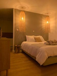 a bedroom with a large bed and two lights at Une parenthèse à la Sarte (wellness) in Huy