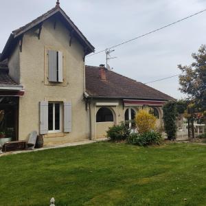 a house with a green lawn in front of it at Gîte à la ferme avec piscine in Urgosse