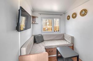 a small living room with a couch and a tv at Casa Amarelo-Tiny House with fantastic view-pool and close to the beaches in Silves