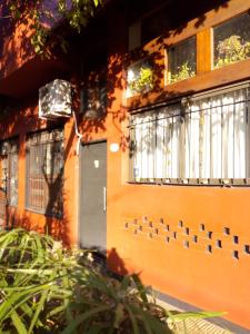 pomarańczowy dom z drzwiami i oknami w obiekcie Bicicleteria Don Perez w mieście San Isidro