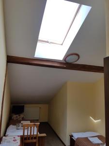 a attic room with a skylight and two beds at Karczma na Woli in Biłgoraj