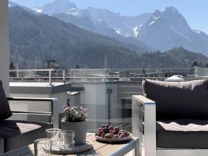 Un balcón con una mesa con un bol de fruta. en Apartment BergArt, en Garmisch-Partenkirchen