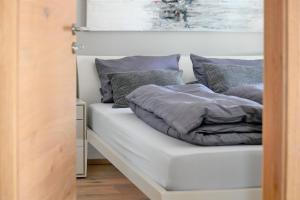 a bed with grey pillows on top of it at Apartment BergArt in Garmisch-Partenkirchen