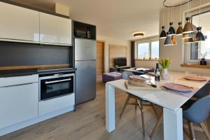 cocina y sala de estar con mesa blanca y electrodomésticos en Apartment BergArt, en Garmisch-Partenkirchen