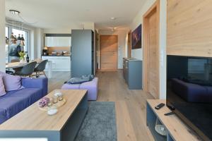 uma sala de estar com um sofá roxo e uma mesa em Apartment BergArt em Garmisch-Partenkirchen