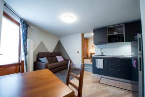 eine Küche und ein Wohnzimmer mit einem Tisch und einem Sofa in der Unterkunft Lou Rosé in Donnaz