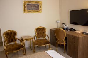a room with two chairs and a desk and a television at Khan Khediwe Hotel in Amman