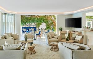 a living room with couches and a flat screen tv at Hotel Le Suquet Cannes in Cannes