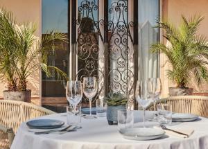 a table with wine glasses and plates on it at Hotel Le Suquet Cannes in Cannes