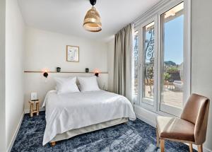 a bedroom with a bed and a window and a chair at Hotel Le Suquet Cannes in Cannes +30 photos