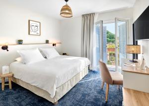 um quarto de hotel com uma cama e uma varanda em Hotel Le Suquet Cannes em Cannes