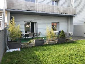 a house with a patio with potted plants on the lawn at Le defi in Fouras