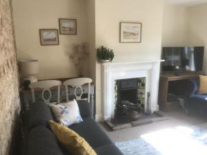 a living room with a couch and a fireplace at Lovely 3-Bed Cottage in Brancaster Staithe in Brancaster